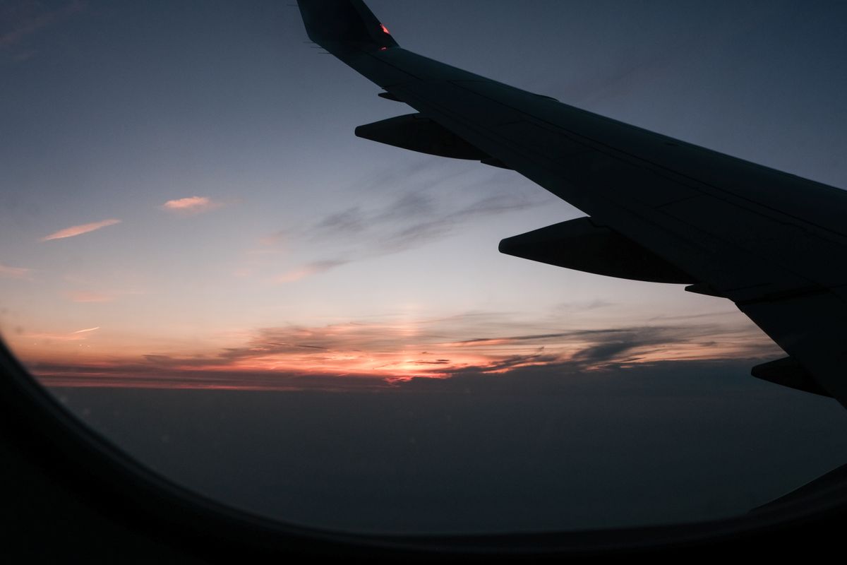 View of an airplane wing at sunset from a window seat